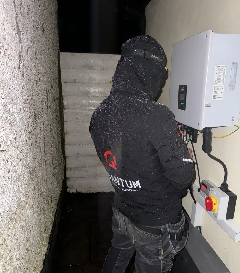 Electrician in winter gear working on outdoor unit
