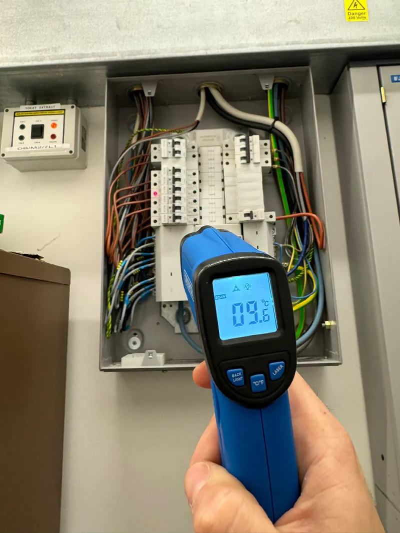 Infrared thermometer measures electrical panel temperature.